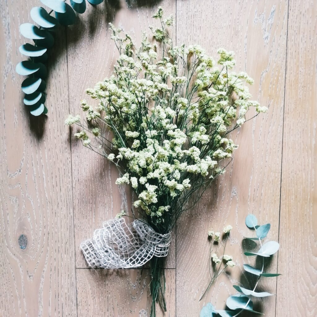 a bouquet of white flowers sitting on top of a wooden floor